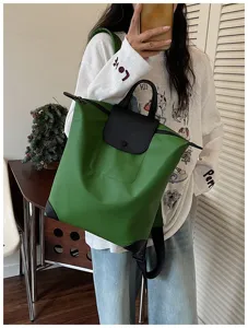 Zaino in nylon casual con manico superiore e chiusura a patta per uso quotidiano.
