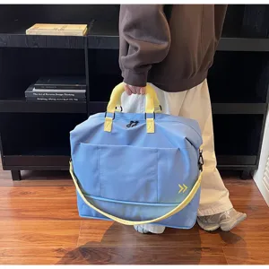 Detailed view of the large capacity travel duffel bag with yellow straps and front pocket.