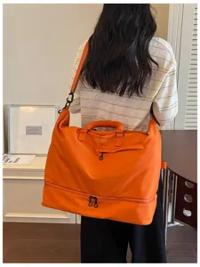 Detail view of large orange travel duffel bag with zipper for sports, gym and weekend trips.