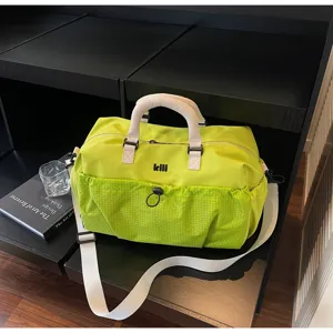 Travel duffel bag detail view showcasing green nylon fabric, white handles, and front mesh pocket.