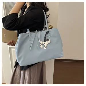 Light blue large capacity tote bag detail view with a cute dog pendant and dual straps.