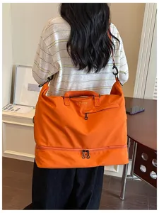 Large capacity orange travel duffel bag with bottom compartment, shoulder strap and casual design.