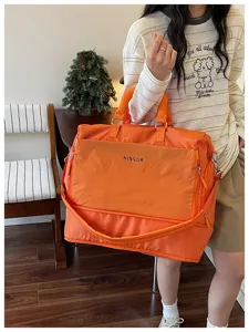 Grand sac de voyage orange avec bandoulière, idéal pour les courts séjours et le sport.