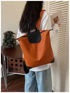 Zaino casual arancione da lavoro con manico superiore e patta nera per uso quotidiano.