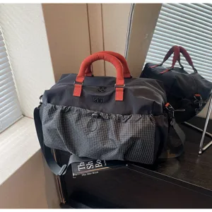 Large capacity travel duffel bag with front checkered pocket and red handles for gym or trips.