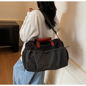 Large capacity duffel bag with grid front pocket, perfect for travel and gym use.