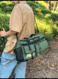 Detail view of the large capacity green grid travel duffel bag in outdoor scene.
