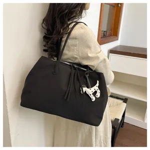 Large capacity shoulder tote bag with cute dog charm, stylish commuting bag for women.
