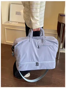 Detail view of the large capacity travel duffel bag with a separate bottom compartment in purple.
