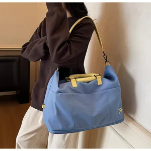Large capacity travel duffel bag detail, blue canvas gym bag with yellow straps and handles.
