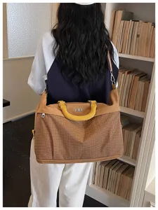 Vista dettagliata della grande borsa da viaggio con elegante motivo a quadri e comode maniglie.