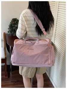 Vue détaillée du grand sac de voyage rose avec poche en filet pratique pour femmes.