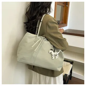 Large capacity shoulder tote bag with cute dog pendant, stylish commuter bag for daily use.