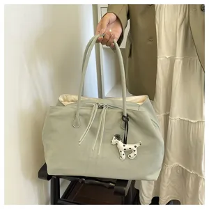 Light green canvas tote bag with cute puppy pendant, spacious commuter shoulder bag for daily use.