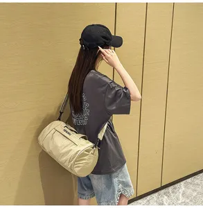 Cylindrical gym duffel bag in khaki, portable shoulder strap, ideal for sports and travel use.