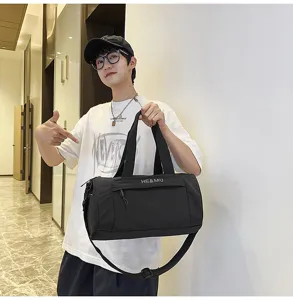 Detail shot of the black sports duffel bag held by a model, showing durable strap and handle.
