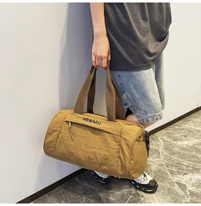 Khaki fitness travel duffel bag with front zipper pocket and sturdy handles, detail view.