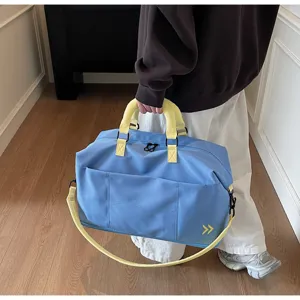 Large capacity blue travel duffel bag detail with yellow straps and sturdy handle.
