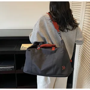 Large capacity travel duffel bag for women and men, stylish gym sports bag with red handles.