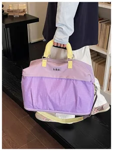Grande borsa da viaggio viola con manici gialli e cinghie regolabili, vista dettagliata.