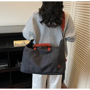 Large capacity travel duffel bag for women and men, weekend overnight bag with red strap.