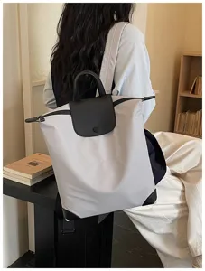 Vista dettagliata dello zaino casual con patta in pelle nera e maniglia superiore.