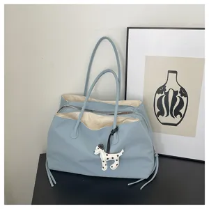 Detail view of the light blue large capacity tote shoulder bag featuring a cute puppy pendant.
