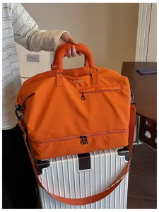 Large capacity travel duffel bag for women and men, gym sports bag with shoe compartment orange.