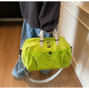Green travel duffel bag detail, large gym bag with front pocket, sturdy handles and strap.