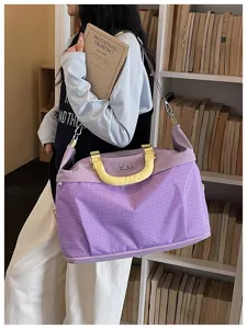 Vista dettagliata della grande borsa da viaggio viola a quadretti con manico e tracolla gialla.