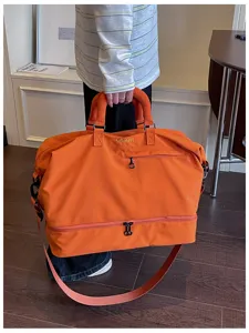 Large capacity orange travel duffel bag detail, gym sports bag with shoulder strap.