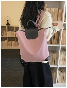 Zaino casual in nylon rosa con patta in pelle nera e manico superiore per lavoro quotidiano.