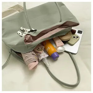 Sage green large capacity tote bag detail, showing spacious interior and daily essentials.