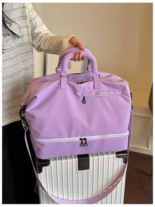 Detail view of large capacity travel duffel bag with bottom compartment and comfortable handles.