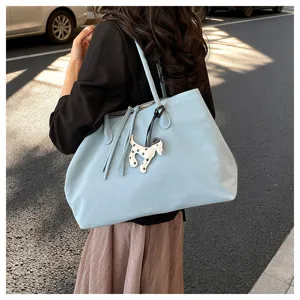 Light blue tote bag with cute dog charm, large capacity stylish shoulder bag for daily commute.