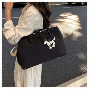 Black large capacity tote bag with cute dog pendant, stylish commuter shoulder bag for women.