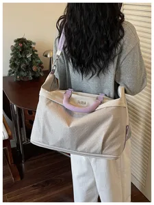 Grande borsa da viaggio con tracolla e manici viola per brevi spostamenti e sport.