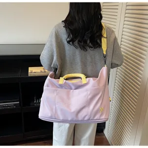 Detailed view of large capacity travel duffel bag in light purple with yellow straps, back view.