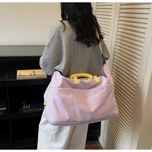 Detailed view of the large capacity travel duffel bag in purple with yellow handles.
