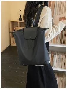 Zaino da commuter nero minimalista casual da viaggio con manico superiore e patta.