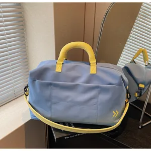 Large capacity blue travel duffel bag detail showing durable fabric, sturdy handles and front pocket.