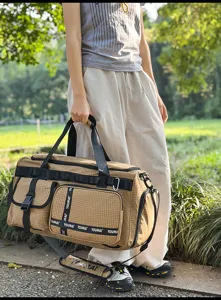 Outdoor travel duffel bag detail, khaki plaid pattern, durable shoulder strap and buckles.
