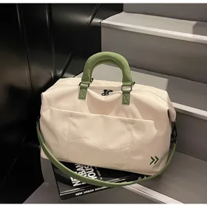 Detail shot of the cream and green travel duffel bag showing durable canvas fabric and sturdy handles.
