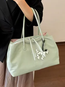 Chic light green tote bag with cute puppy charm, stylish shoulder bag for daily commute.