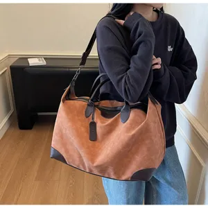 Spaziosa borsa da viaggio retrò in camoscio con finiture in pelle e tracolla ideale.