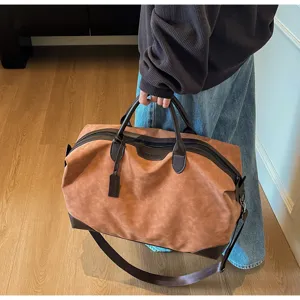 Primo piano di una borsa da viaggio marrone con dettagli in pelle scura e capiente.