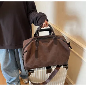 Borsone da viaggio marrone con manici e tracolla, ideale per brevi viaggi e fughe nel weekend.