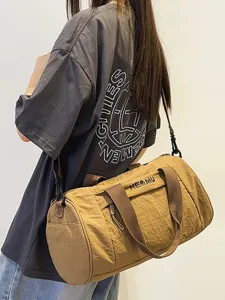 Brown travel duffel bag for sports and fitness with large capacity and adjustable shoulder strap.