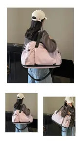 Detailansicht der großen pinken Reise-Sporttasche mit schwarzen Trägern und Taschen im Einsatz.