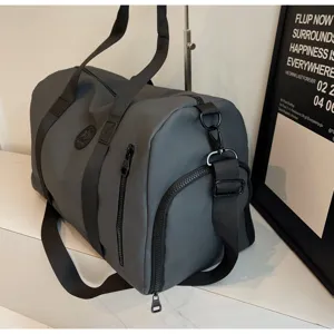 Gros plan sur le sac de sport gris foncé montrant le tissu durable, la poche et les lanières.
